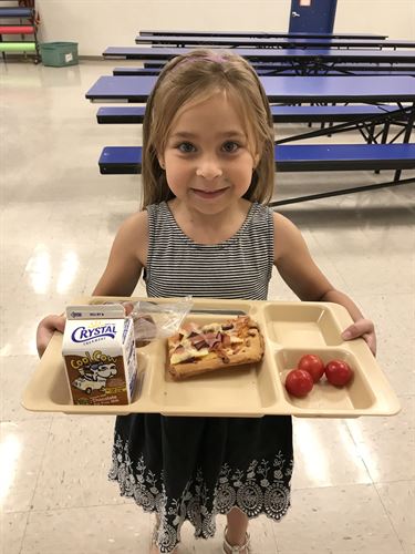 child holding a lunch tray